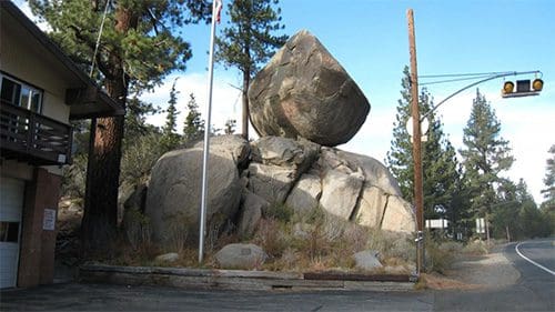 A collection of shiny metallic chess pawns arranged on a peach background.