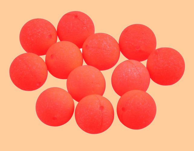 A collection of shiny metallic chess pawns arranged on a peach background.