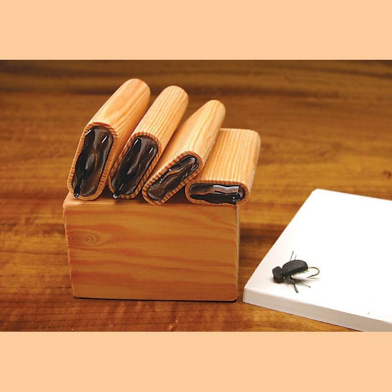 Wooden holder with folded magazines and a notebook on a wooden surface.