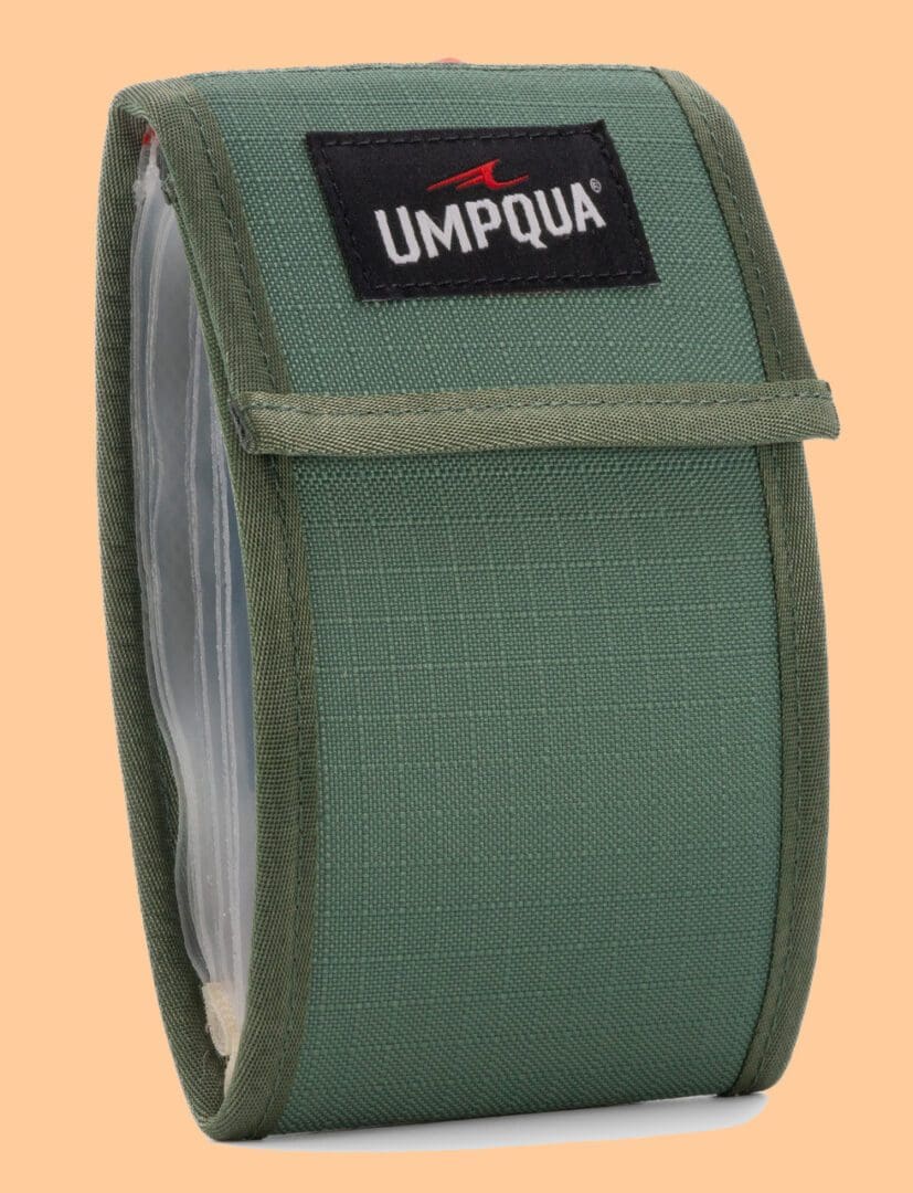 Green Umpqua fly fishing reel case with protective mesh and flap.